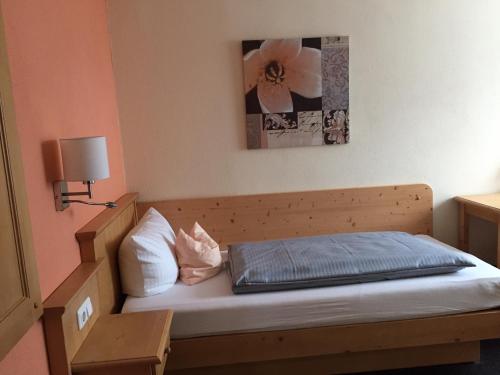 a small bedroom with a bed with a blue blanket at Landhotel Grätz in Emmering