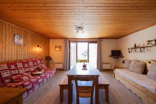 a living room with a couch and a table at L'Edelweiss - Bouvier in Aillon-le-Jeune