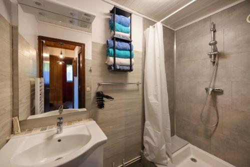 a bathroom with a sink and a shower with a shower curtain at L'Edelweiss - Bouvier in Aillon-le-Jeune