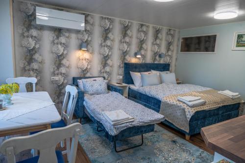 a bedroom with two beds and a table and chairs at Ämmamoori Maja - Mother-in-Law's House in Palmse