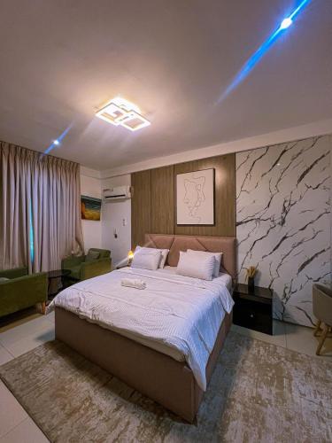 a bedroom with a large bed with a marble wall at Abbey's Home in Ogoyo