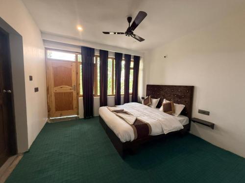a bedroom with a bed and a ceiling fan at Natures View Residency in Hundar