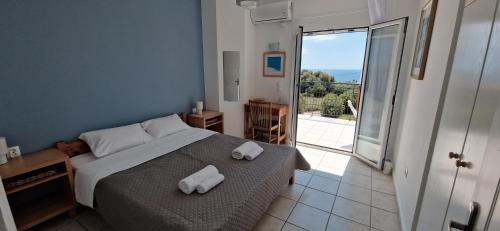 a bedroom with a bed with towels on it at Aquarius Kefalonia in Pesádha