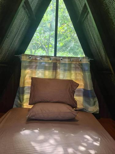 a bed in a tent with a pillow in front of a window at Villa Concepcion Staycation by ngb in Real