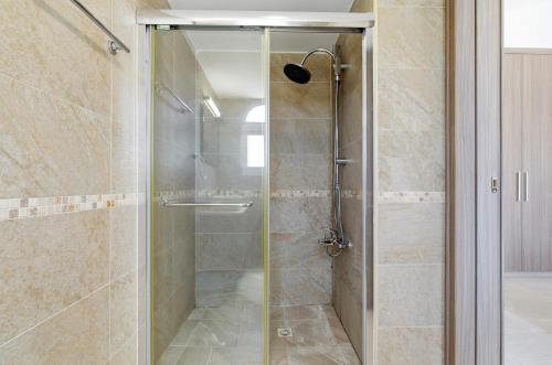 a shower with a glass door in a bathroom at Bungalow Casa Bella by Ezoria Villas in Coral Bay
