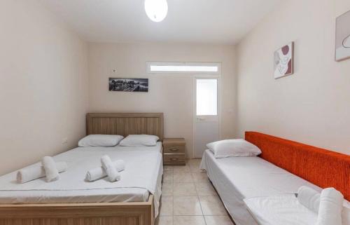 a bedroom with two beds and a window at Lika's Residence in Golem