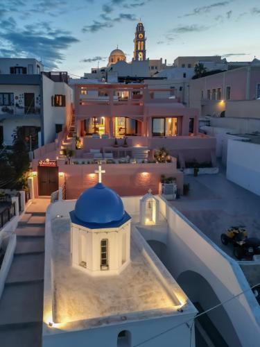 a building on the roof of a house at night at Thianne Luxury Suites in Fira