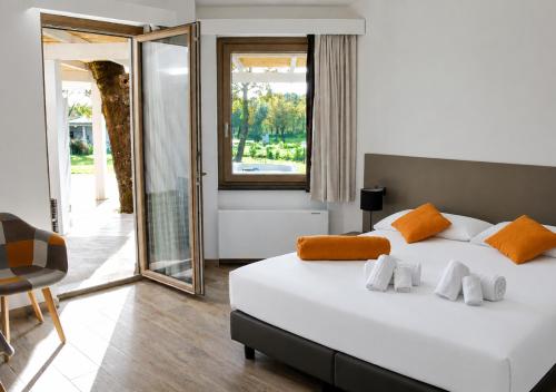 a bedroom with a large white bed and a mirror at Regia Hotel in Abbasanta