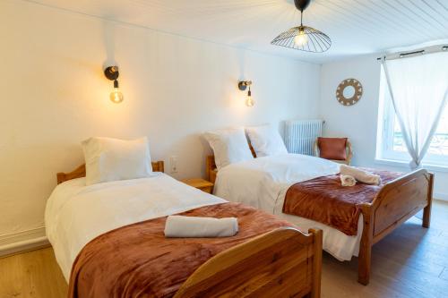 ein Hotelzimmer mit zwei Betten und einem Stuhl in der Unterkunft Le Zigzag in Retournac