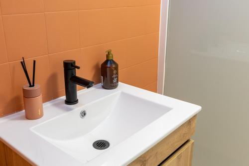 ein Waschbecken im Badezimmer mit einer Weinflasche darauf in der Unterkunft Le Zigzag in Retournac