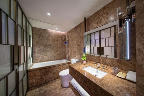 a bathroom with a sink and a toilet and a tub at The Emperor Hotel in Hong Kong