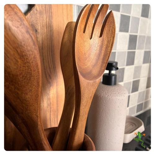 two wooden spoons and a bottle of soap on a counter at The Quiet Creative, Corporate-Ready 1BR in Tatu City