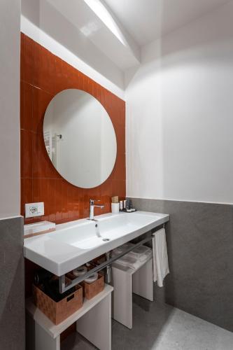 a bathroom with a white sink and a mirror at Velino Business Suite in Avezzano