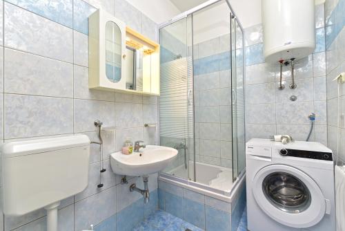 a bathroom with a toilet sink and a washing machine at House Pavicini 333 in Pavicini