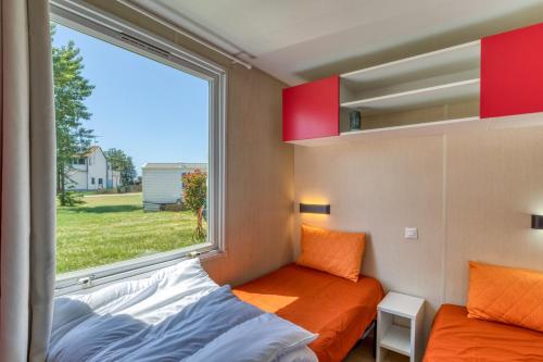 a small bedroom with a window and a bed at Location Mobile home in Marseillan