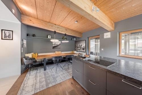 a kitchen with a wooden ceiling and a table at GOING TRIPLE A apartments NORTH in Going am Wilden Kaiser