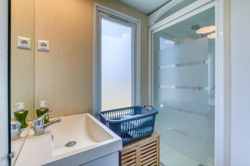 a bathroom with a sink and a large mirror at Location Mobile home in Marseillan
