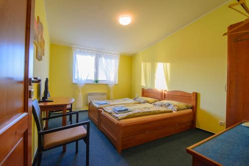 a bedroom with a bed and a table and a chair at Penzion Dyje in Hevlín
