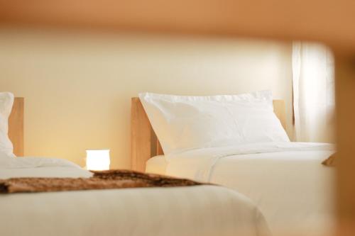 a bedroom with two beds with white sheets at JOSIRE Residence in Entebbe