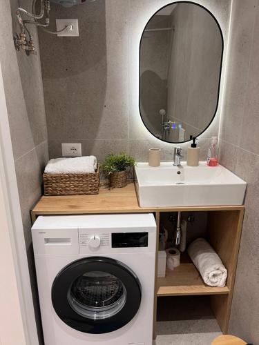 a bathroom with a washing machine and a sink at Palmera Escape Radhime in Vlorë