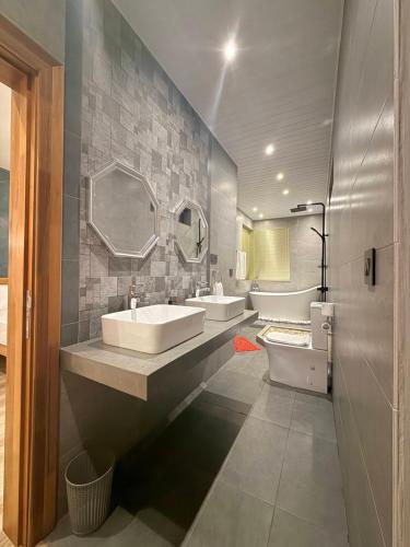 a bathroom with two sinks and a mirror at VLAP Residence in Baie du Tombeau