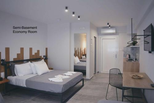 a bedroom with two beds and a table and a dining room at Alesta Apartments in Stavros