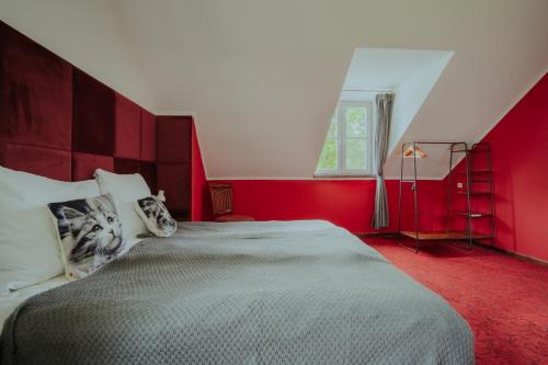a bedroom with a large bed with red walls at Dwór Ujazdowski in Nielisz