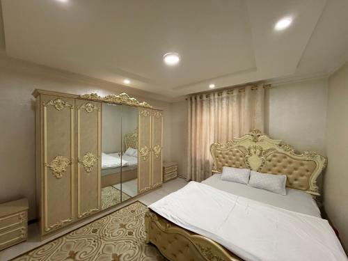 a bedroom with a large bed and a mirror at Apartment Registon in Samarkand