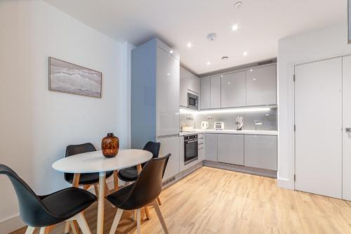 a kitchen and dining room with a table and chairs at Modern 1Bed Flat in Ealing Near Tube & Shops in Ealing