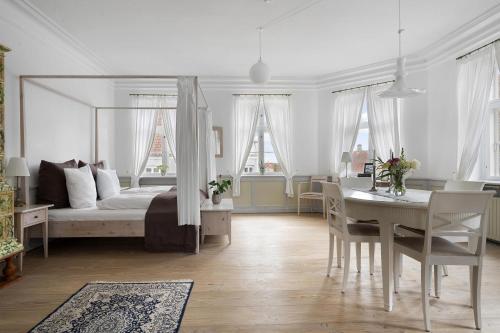 a bedroom with a bed and a table and a dining room at Brodremenighedens Hotel, BW Signature Collection in Christiansfeld