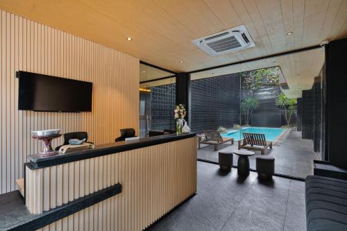 a living room with a television and a swimming pool at M4YA Berawa in Canggu