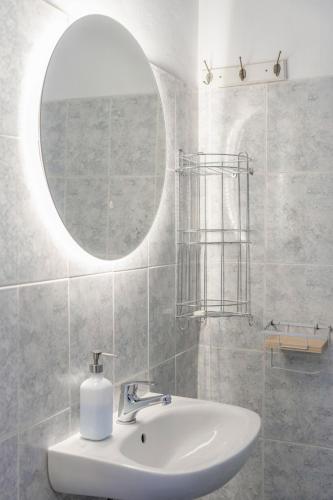 a bathroom with a sink and a mirror at Thanos' seaside apartment in Oropos