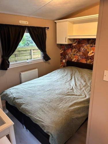 a bedroom with a bed and a window at Leuke 6 persoons stacaravan op top locatie! in Hoenderloo