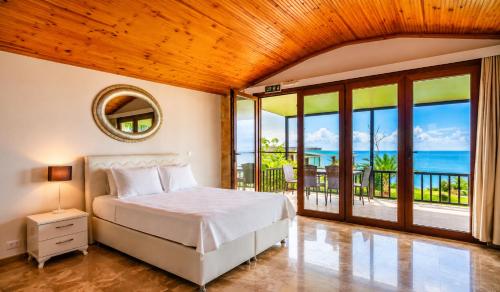 a bedroom with a bed with a view of the ocean at Palm Beach Şile Villa Hotels in Şile