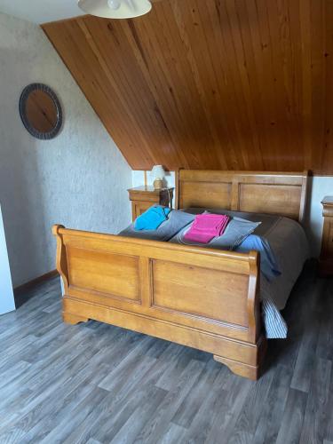 a wooden bed in a room with a wooden ceiling at Maison Entre Terre et Mer in Primelin