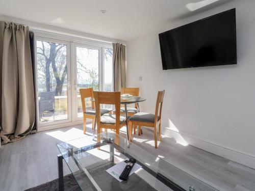 a living room with a table and chairs and a television at Beacon Fell Cottage 2 in Preston