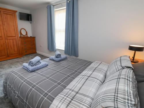 a bedroom with a bed with towels on it at Naseby House in Alfreton