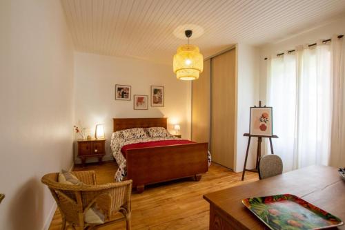 a bedroom with a bed and a table at L' ebénisterie in Tocane-Saint-Apre