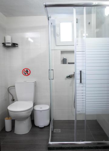 a bathroom with a toilet and a glass shower at SpoonLand in Néa Koútali