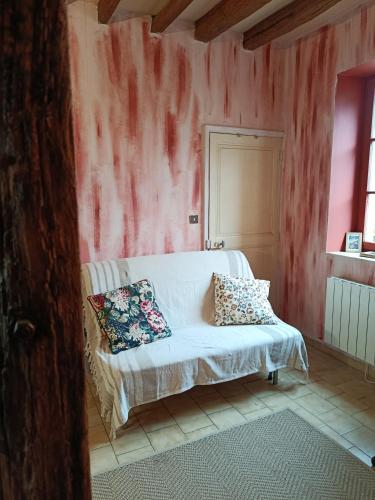 a bedroom with a bed with a pink wall at La fermette de Vrinette in Saint-Vérain