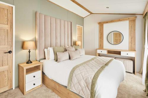 a bedroom with a large white bed and a mirror at Host & Stay - Rose Lodge in Pocklington