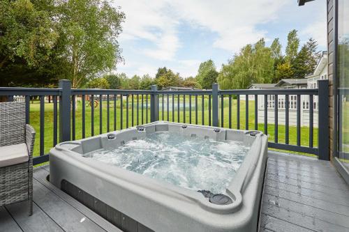 a hot tub on a deck with a fence at Host & Stay - Rose Lodge in Pocklington