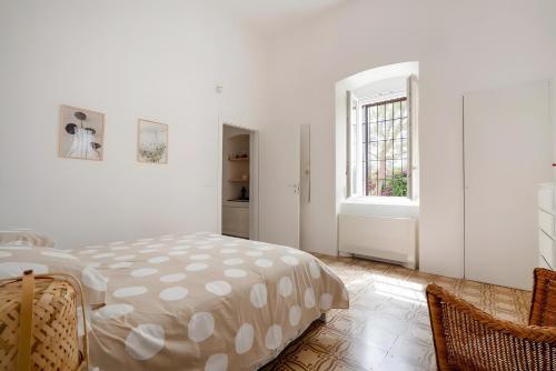 a white bedroom with a bed and a window at Exclusive Maison Valentina in Monopoli