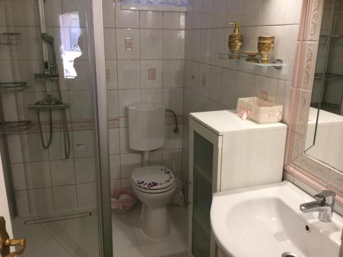 a bathroom with a toilet and a sink and a shower at Jarmila Vendégház in Balatonberény