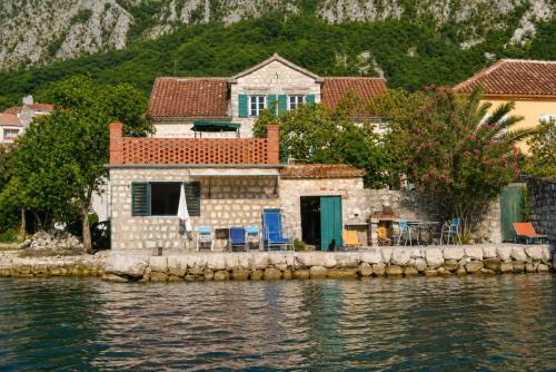 a house on the shore of a body of water at Apartments Subotic in Risan