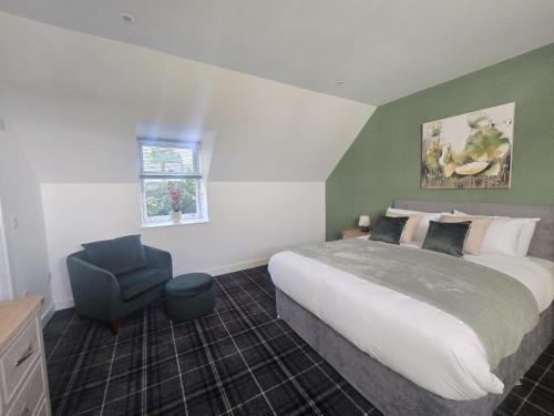 a bedroom with a large bed and a chair at Woodside House in Crook of Alves