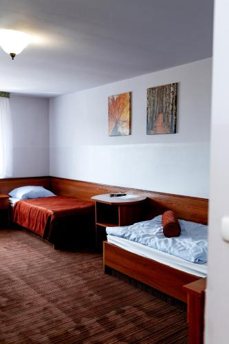 a hotel room with two beds and two tables at Szept Beskidów in Milówka
