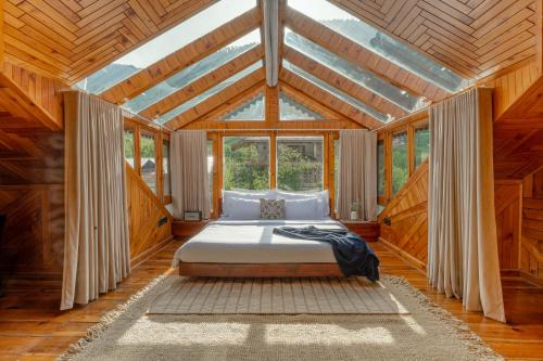 a bedroom with a bed in a wooden ceiling at Padma Villa - Mountain Estate in Manali in Manāli