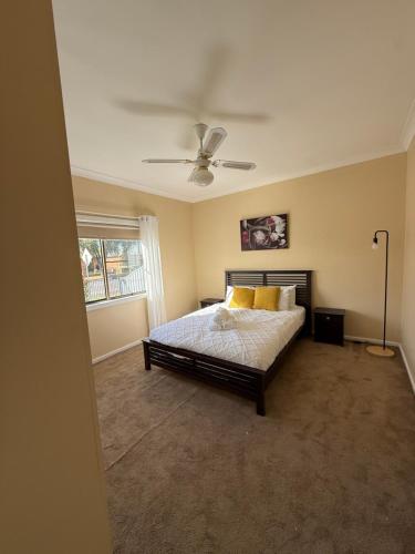 a bedroom with a bed and a ceiling fan at Ferguson House in Cessnock