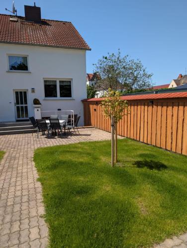 a patio with a table and chairs and a fence at Ferienhaus "Fritz" mit 3 Schlafzimmern in Seenähe in Löbnitz